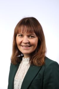 Cardiff Cancer Research Hub haematology expert Dr Ceri Bygrave wearing black jacket and cream shirt